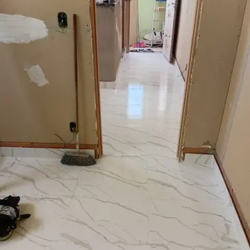 Paginação contínua de porcelanato marmorizado polido com juntas retificadas e niveladores a laser
